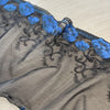 Pizzo floreale con un lato smerlato nero e blu