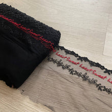  Pizzo nero con un lato impreziosito da una scritta ricamata