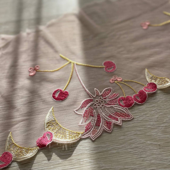 Pizzo floreale rosa con un lato smerlato con disegno ciliegie